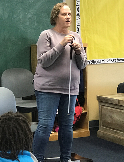 Debbie Wunder shows off a toddler-sized white cane at a preschool visit.